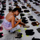 A woman places one of the hundreds of shoes in memory of those killed by Hurricane Maria in front of the Puerto Rico Capitol.